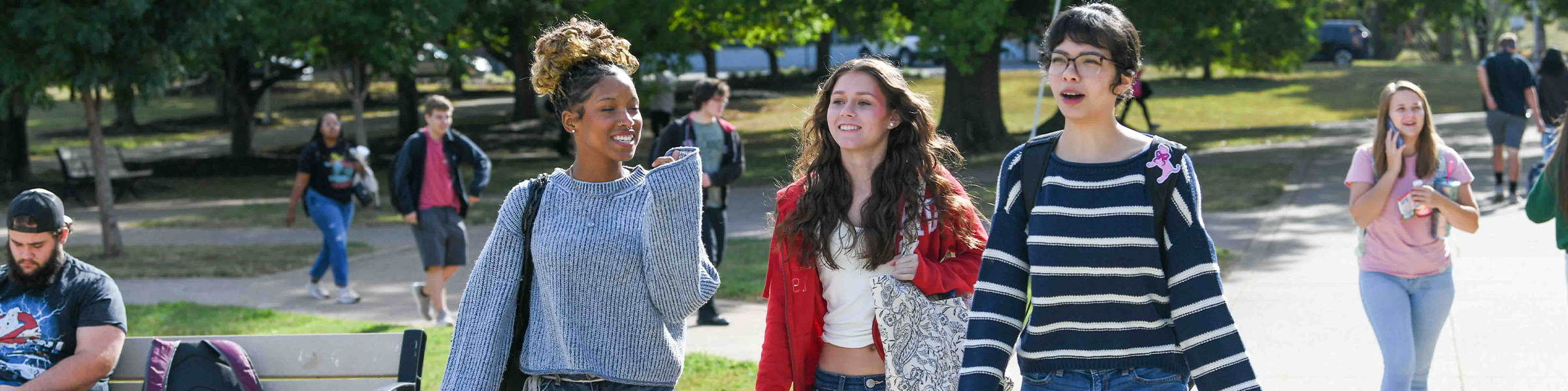 Three female students walking together on a campus pathway