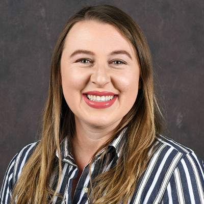 Profile photo of Victoria Zemer, a Pryor Art Gallery Curator, in front of a professional backdrop.