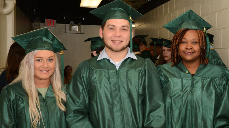 three students at graduation