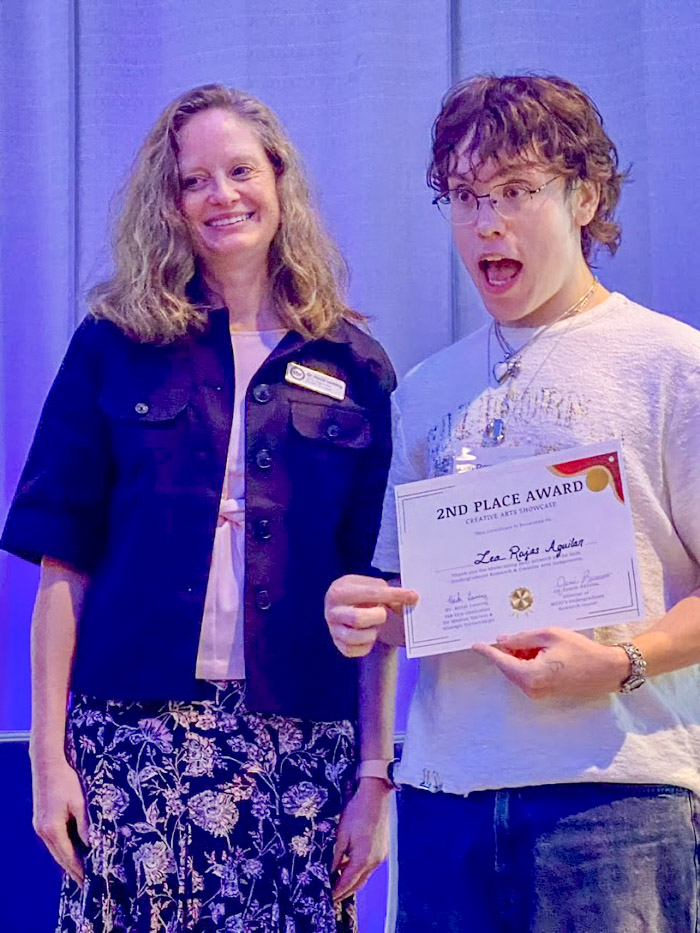 Two people smile and make faces for a photo.